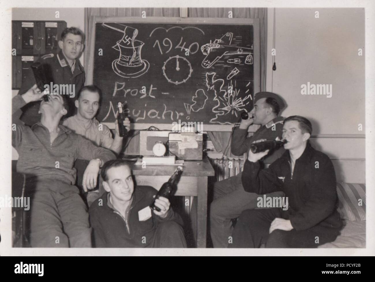 Image from the photo album of Oberfeldwebel Gotthilf Benseler of 9. Staffel, Kampfgeschwader 3: Unteroffizier Gotthilf Benseler answers the phone (rear right) while his fellow airmen of 9./KG 3 celebrate New Year 1940. Stock Photo