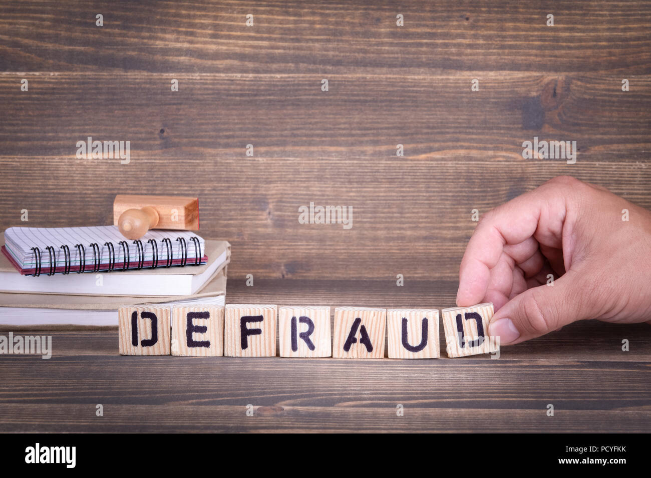 defraud. wooden letters on the office desk Stock Photo - Alamy