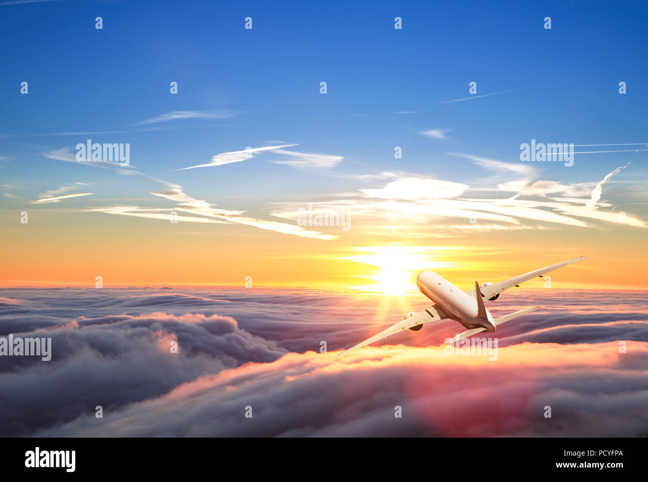 Back view of commercial airplane flying above clouds. Panoramic size ...