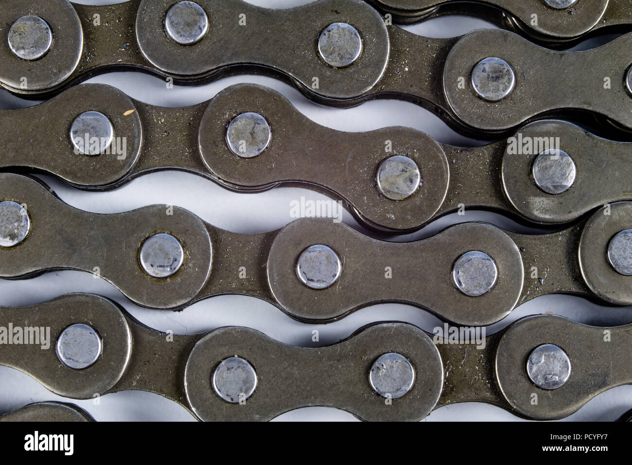 Bike chain arranged on a white table. Periodic servicing of parts for two wheelers. Light background Stock Photo Alamy
