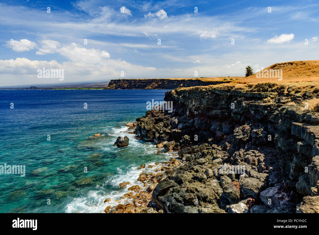 Ka Lae or South Point on the Big Island of Hawaii looking downward at clear water off a rocky cliff Stock Photo