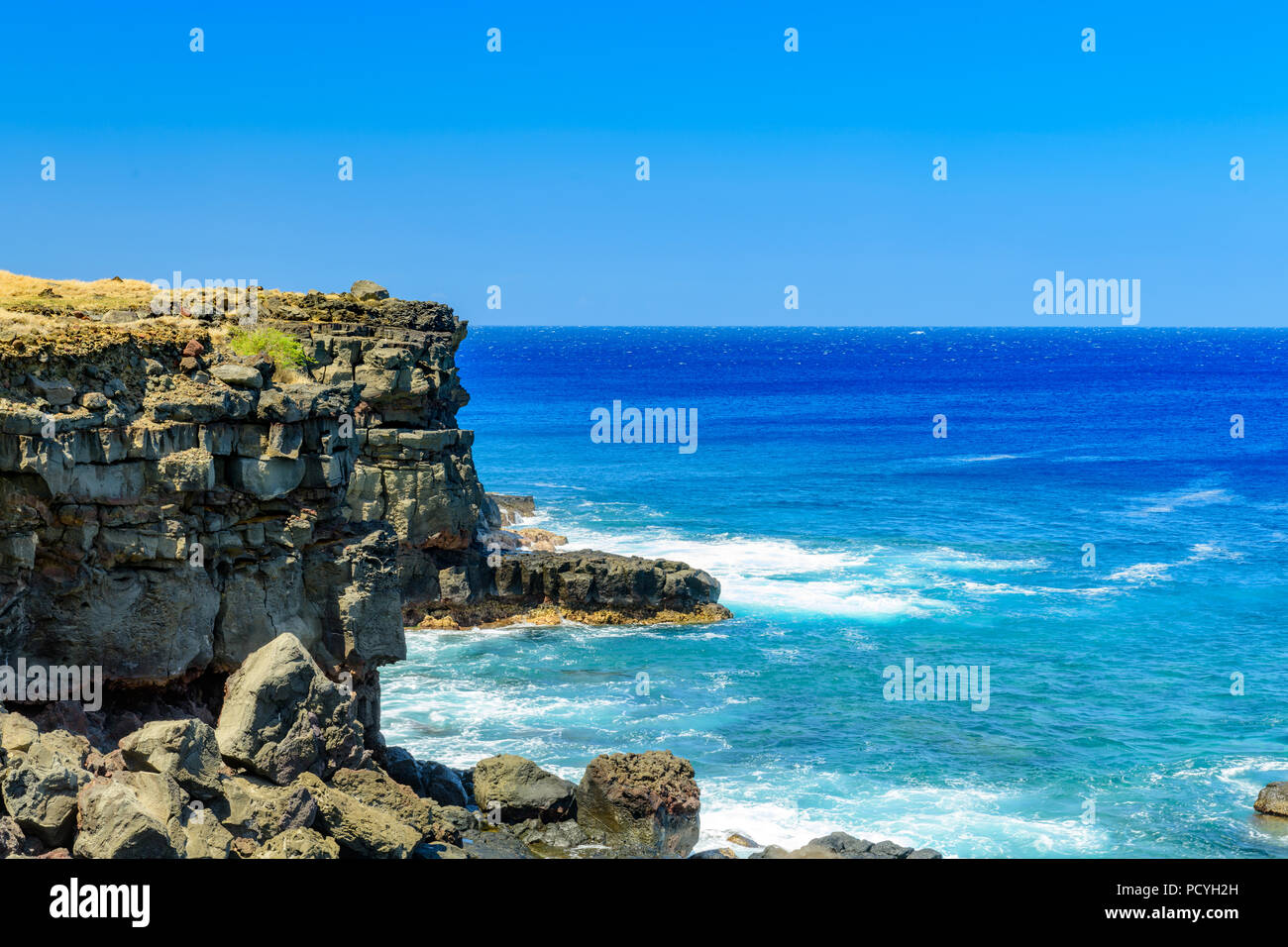 Ka Lae or South Point on the Big Island of Hawaii looking downward at clear water off a rocky cliff Stock Photo