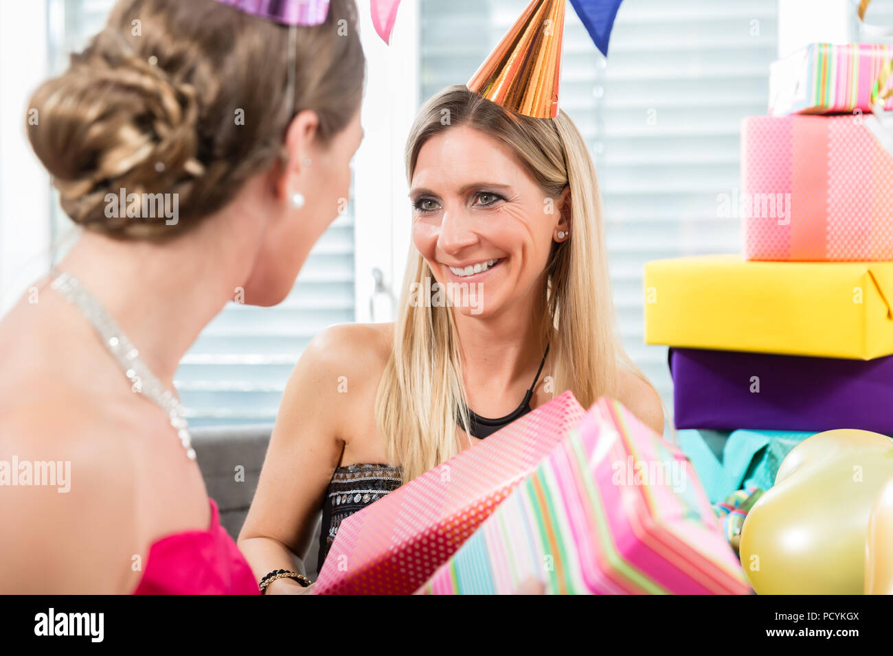Two cheerful women and best friends holding a birthday cake Stock Photo