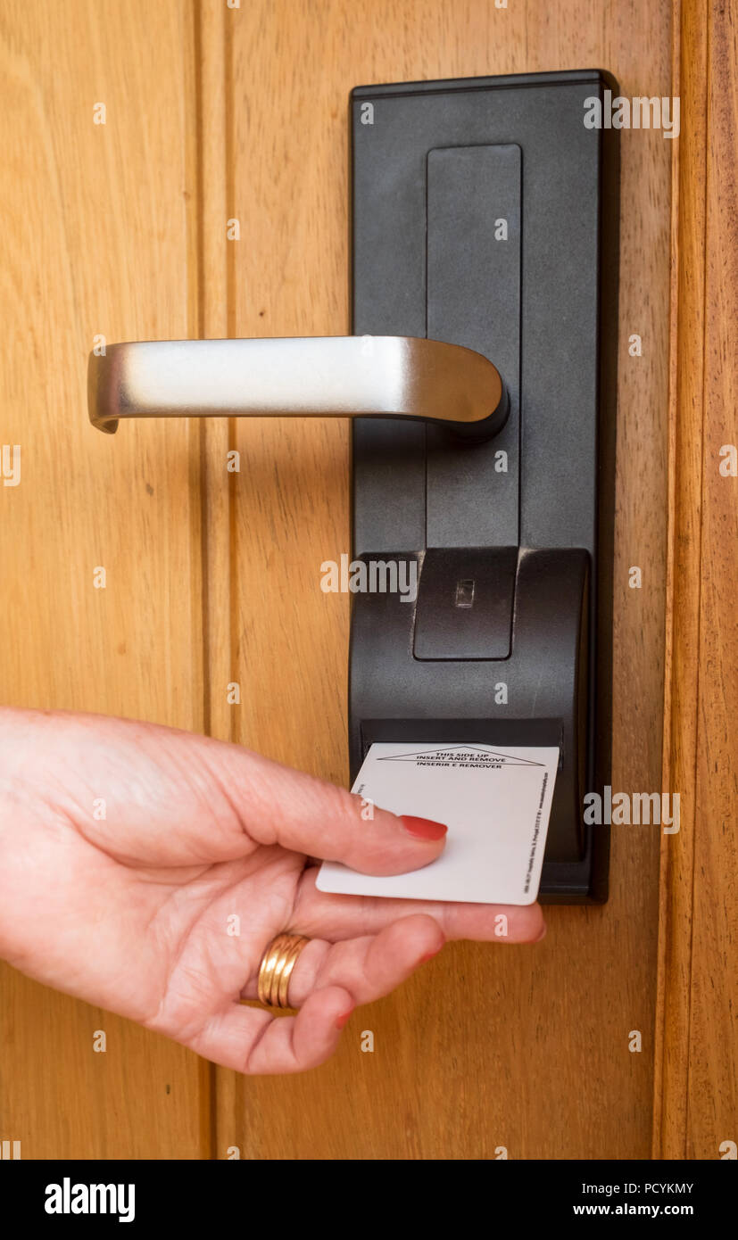 A woman entering a hotel room using an electric key card Stock Photo