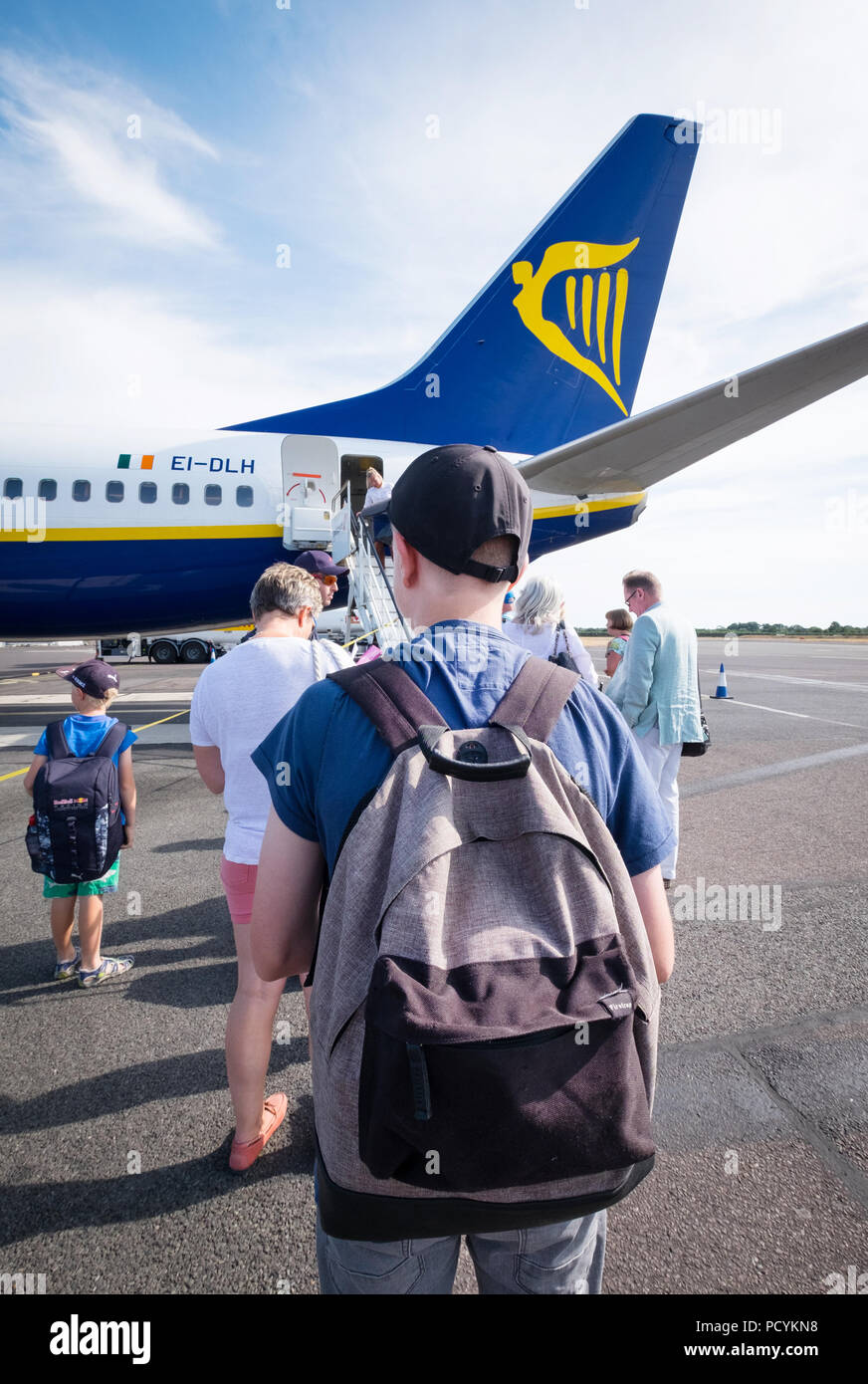 Ryanair passenger with a backpack as carry on hand luggage boarding a Ryanair plane after paying extra for priority boarding. Stock Photo