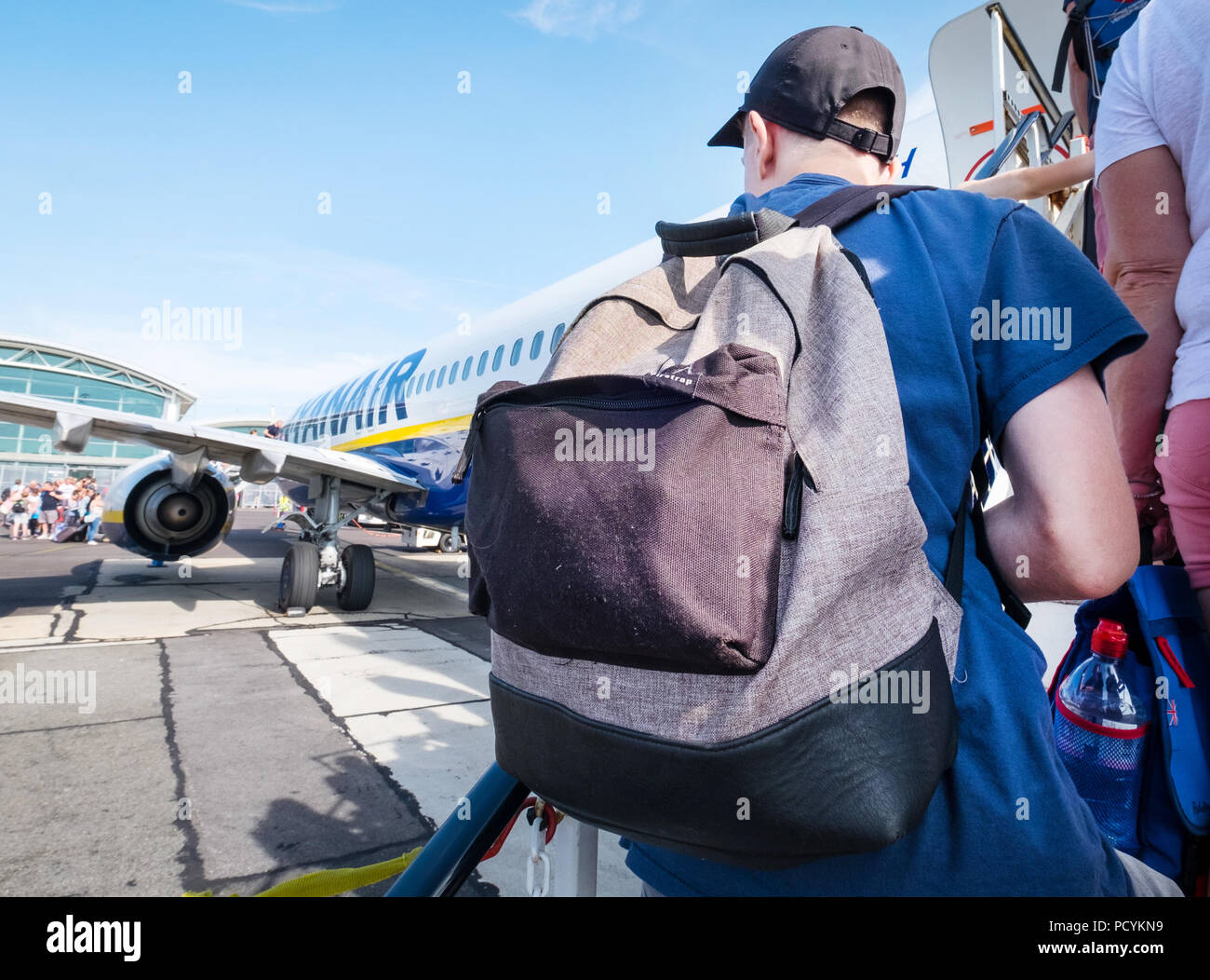 Ryanair passenger with a backpack as carry on hand luggage boarding a Ryanair plane after paying extra for priority boarding. Stock Photo