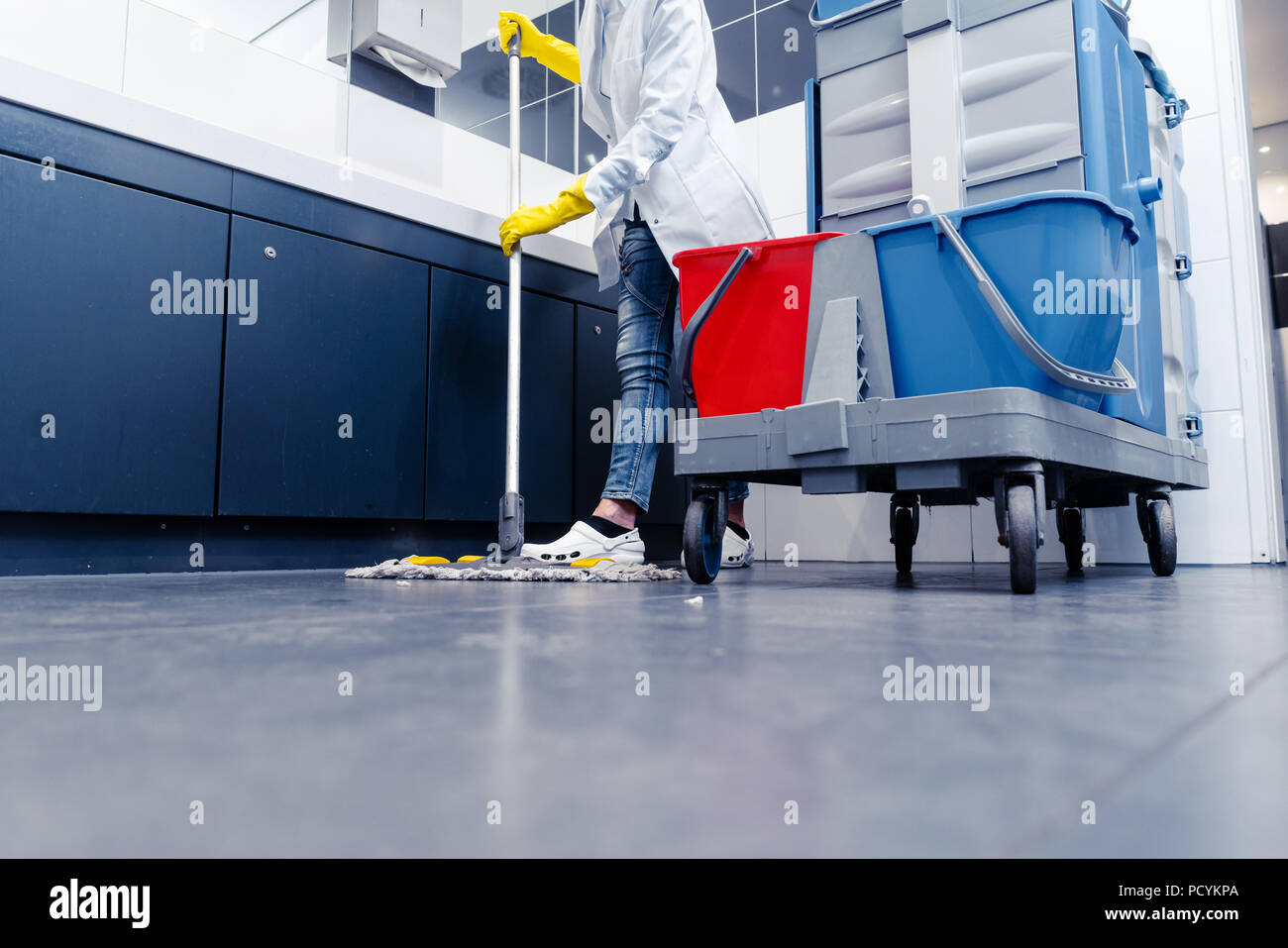 Low shot of cleaning lady mopping the floor in restroom Stock Photo