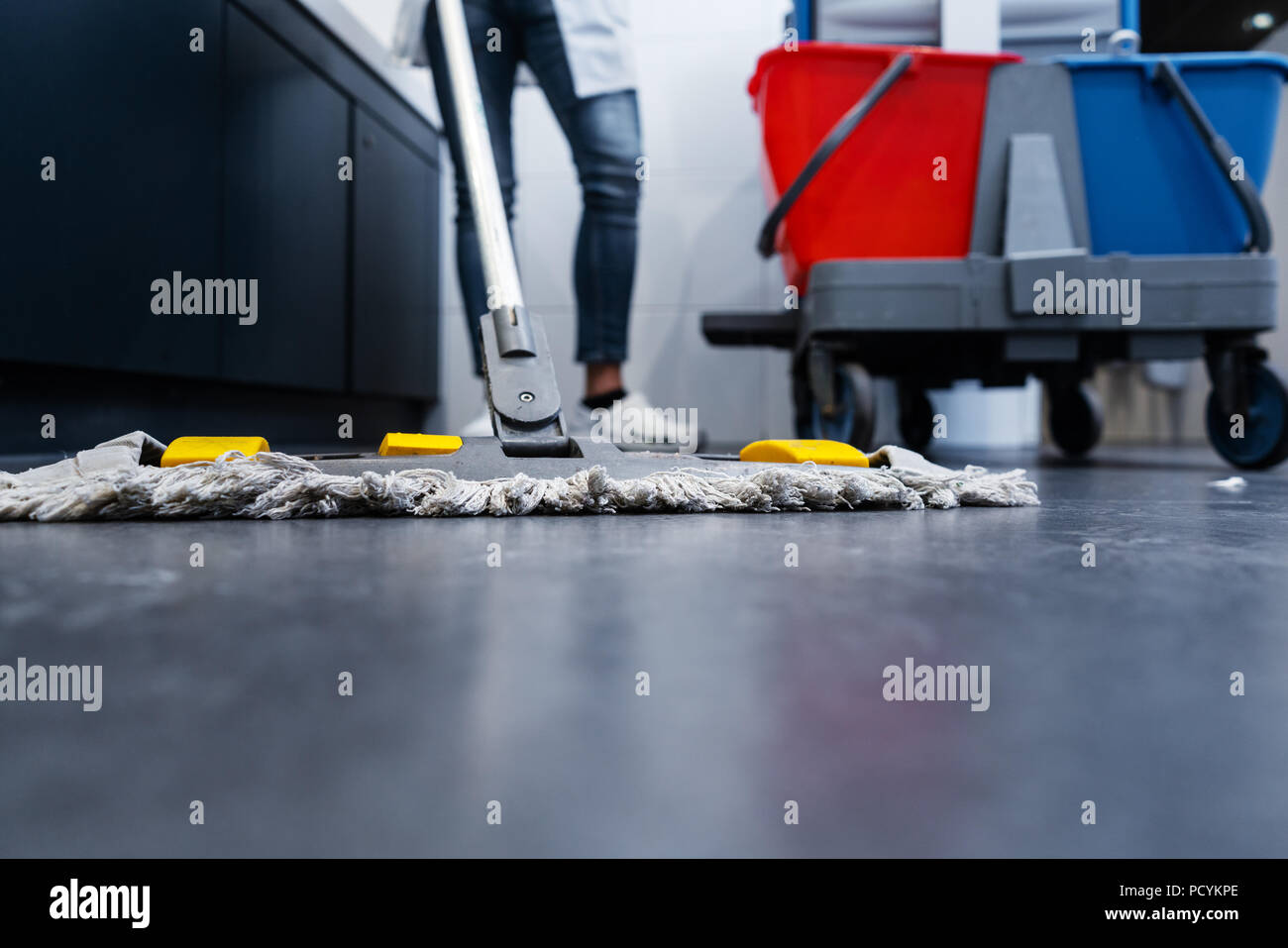 Low shot of cleaning lady mopping the floor in restroom Stock Photo