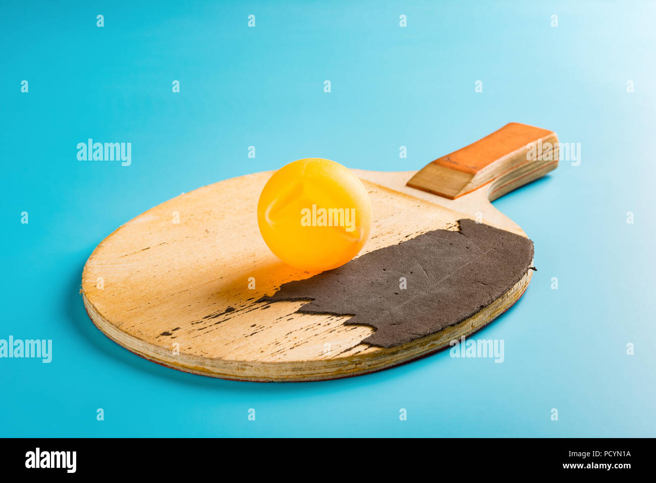 dent pingpong ball and a racket on blue background Stock Photo