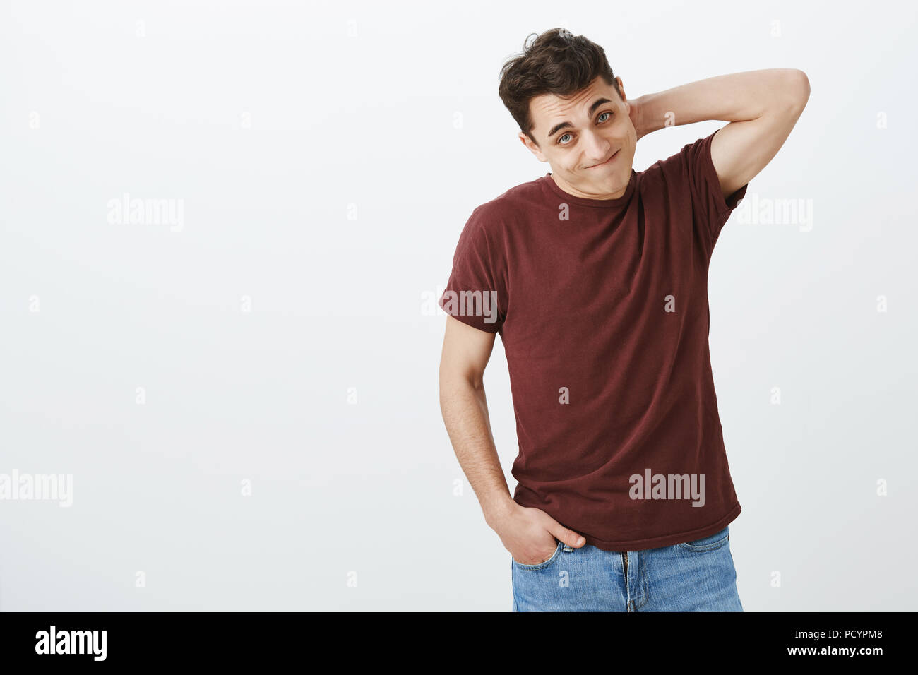 Indoor shot of guilty embarrassed european male model in casual red t