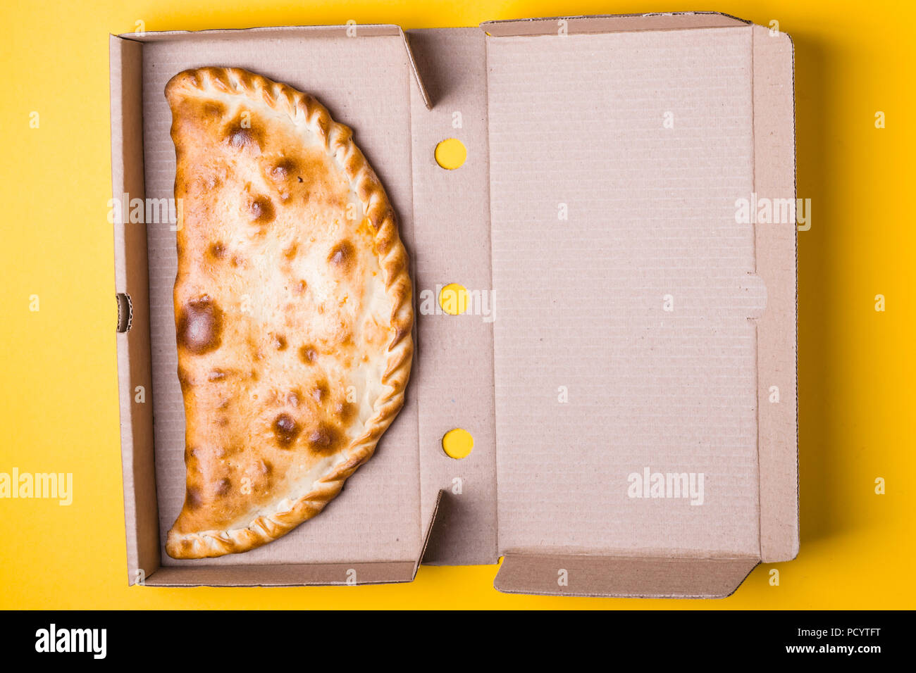Download Closed Pizza Calzone In A Packing Box On A Yellow Background Stock Photo Alamy Yellowimages Mockups
