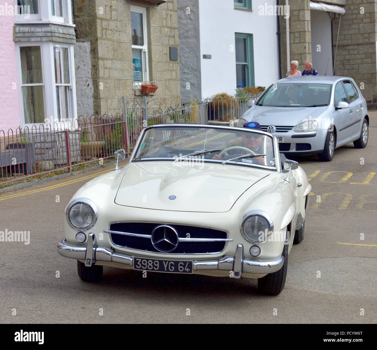 Mercedes 190 SL 2 door Roadster Classic Car passing through the seaside village of Mousehole,Cornwall,England,UK Stock Photo