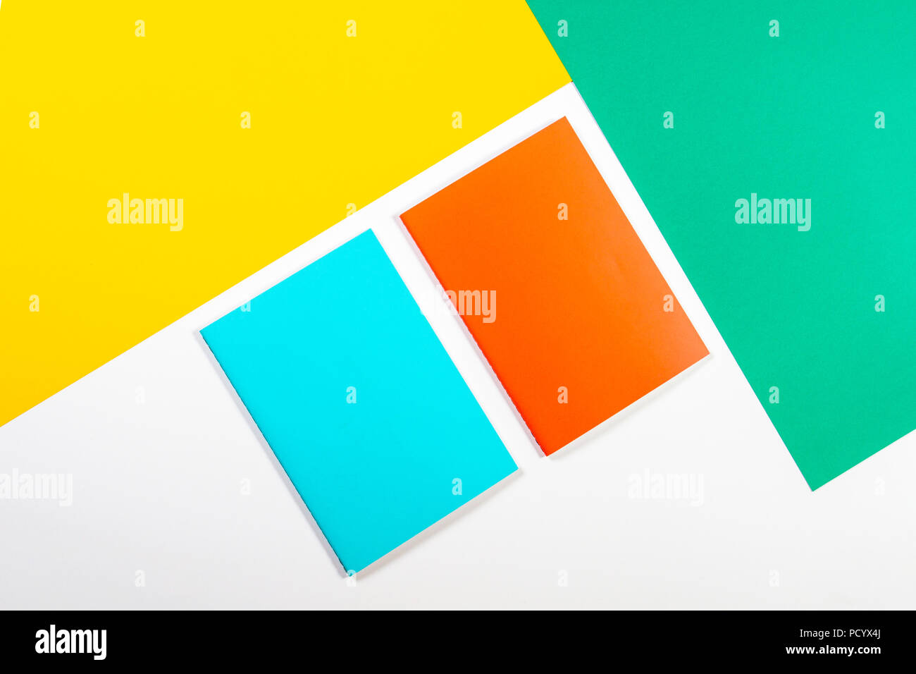 Colorful notebooks on green yellow white background Stock Photo - Alamy