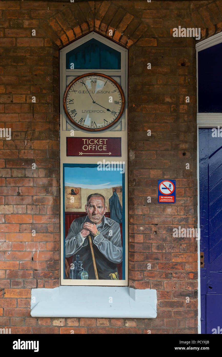 A no-longer used window in the building at the Historic Railway Station of Padgate has a painting of local character actor, Pete Postlethwaite, Warrin Stock Photo