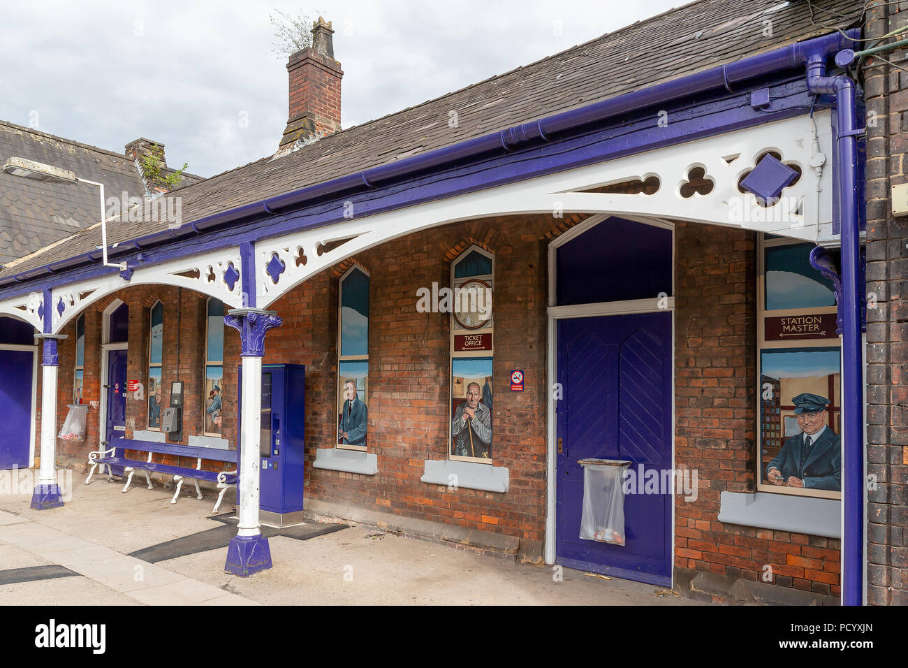 A row of no-longer used windows in the buildings have had pictures painted in them along the platform at the Historic Railway Station of Padgate, Warr Stock Photo