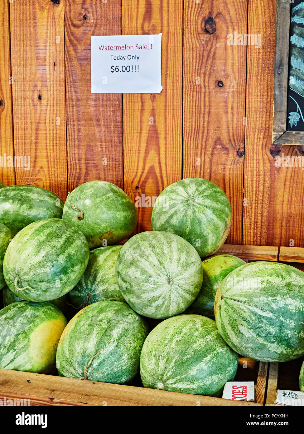 Watermelon fruit stacked on display for sale at a roadside farm or farmer's market in rural Alabama, USA. Stock Photo