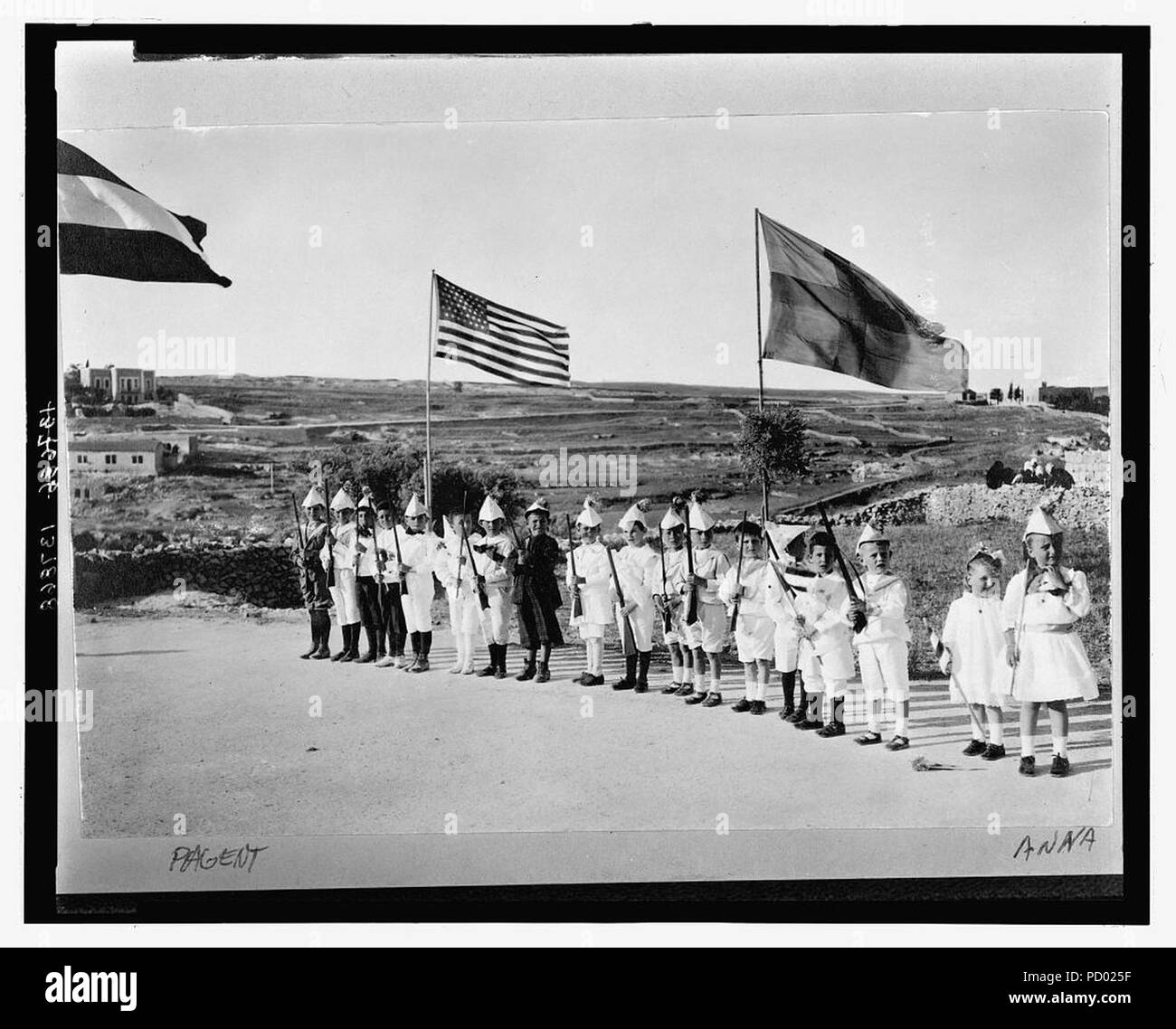 American Colony children in Fourth of July pageant, Jerusalem, showing boys lined up holding toy rifles and Anna Grace and Tanetta Vester holding flags Stock Photo