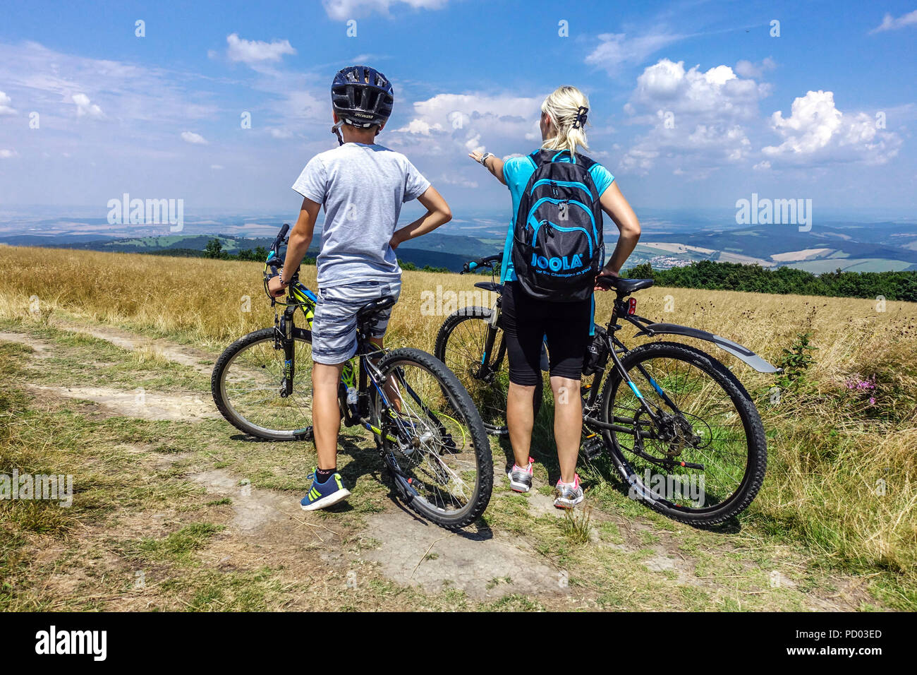 Bikers cycling on a mountain trail, Velka Javorina mountain,  Czech Slovak border in White Carpathians Mountains Czech Republic cycling countryside Stock Photo