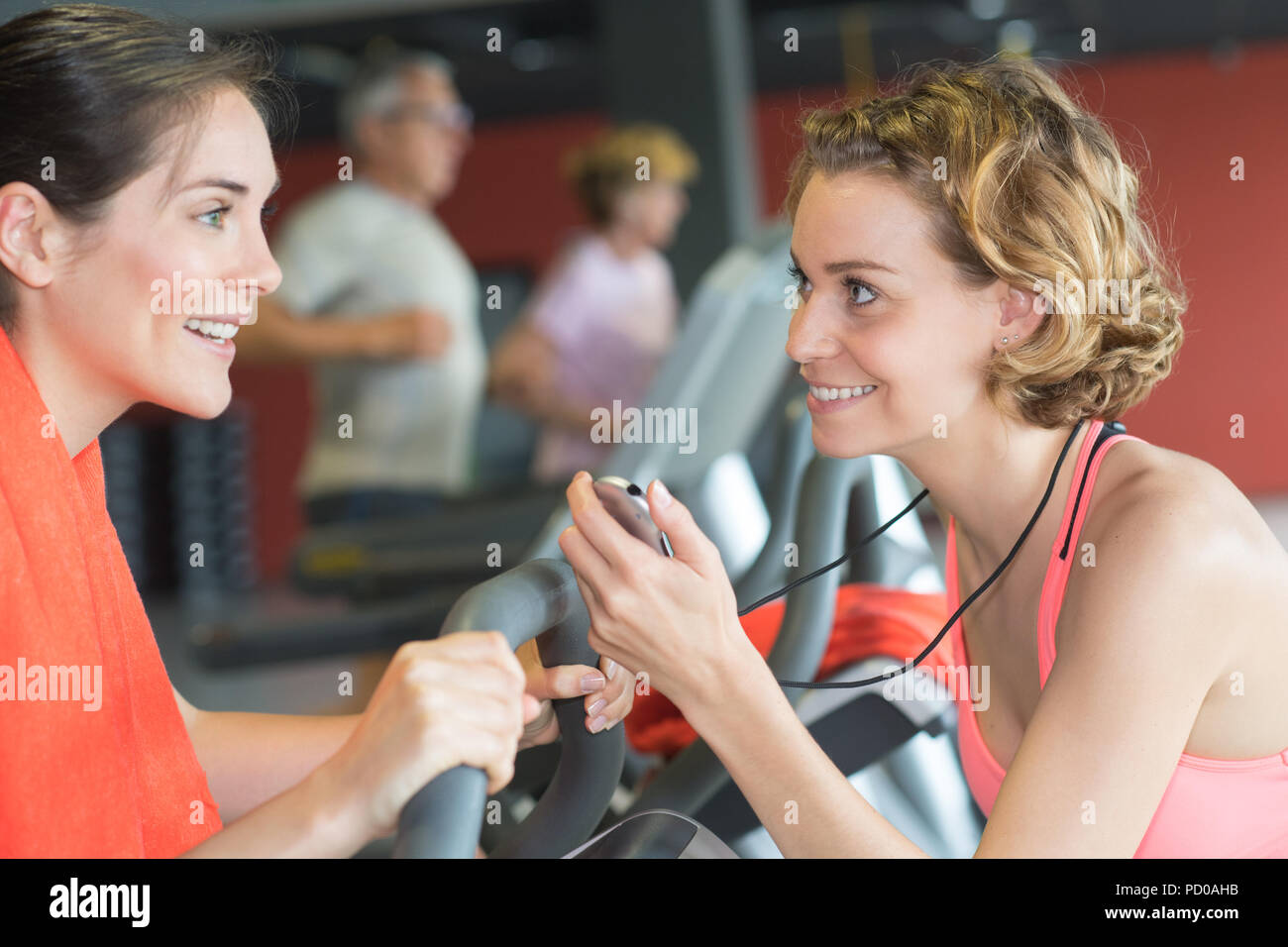 Personal trainer with stopwatch encouraging female client Stock Photo