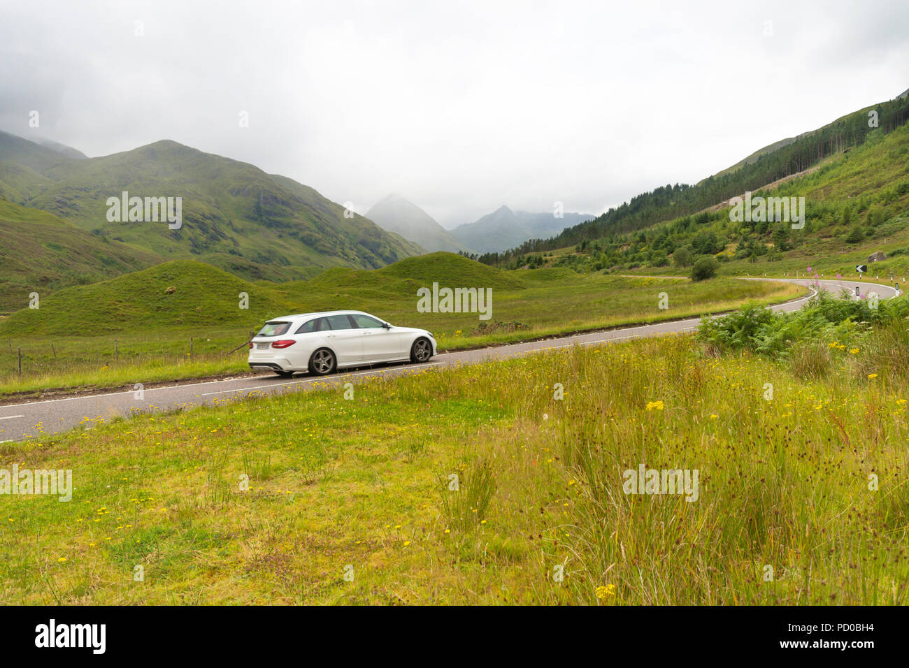 A car drives through the Scottish highlands, Scotland, UK Stock Photo