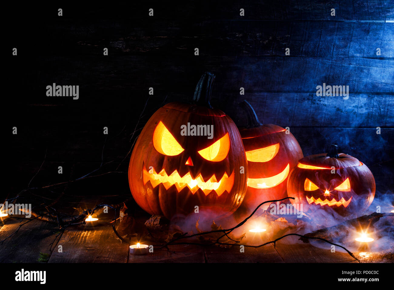 Halloween pumpkin heads jack o lantern, candles tree branch and mist on ...