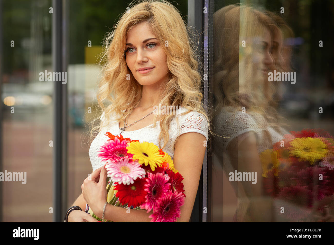 happy young blond woman with bouquet of flowers smiling Stock Photo - Alamy
