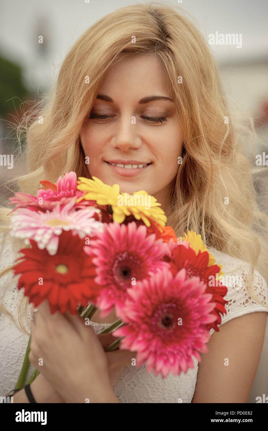happy young blond woman with bouquet of flowers smiling Stock Photo - Alamy