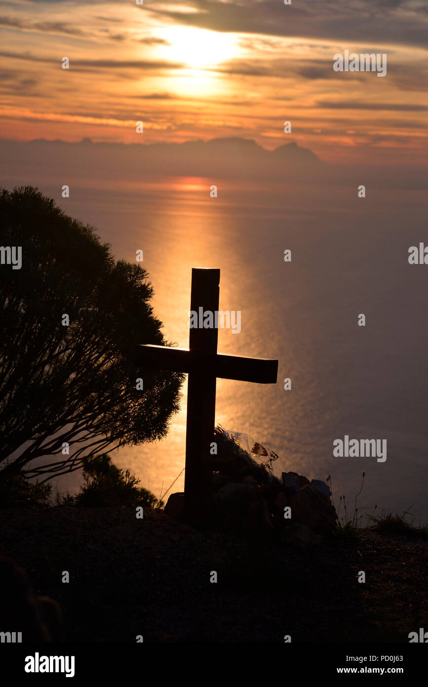 South Africa. Cross silhouetted against sunset over False Bay and Table Mountain near Cape Town. Stock Photo