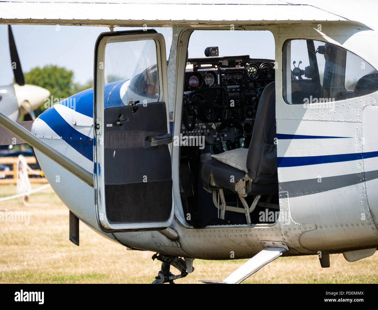 Light aircraft on airfield, door open, showing cockpit Stock Photo