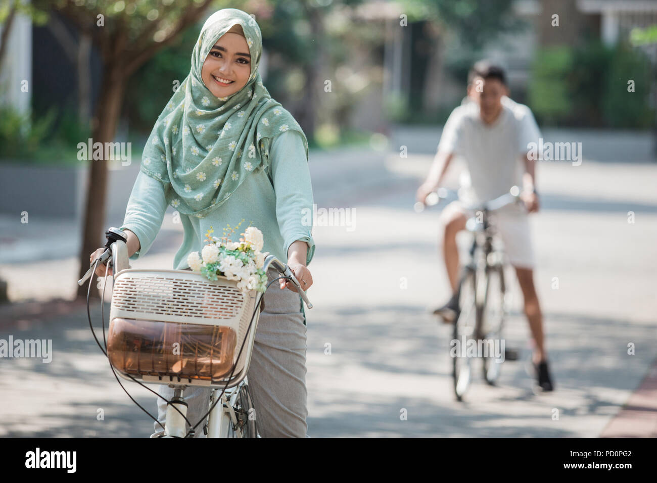 muslim woman riding a bicycle Stock Photo