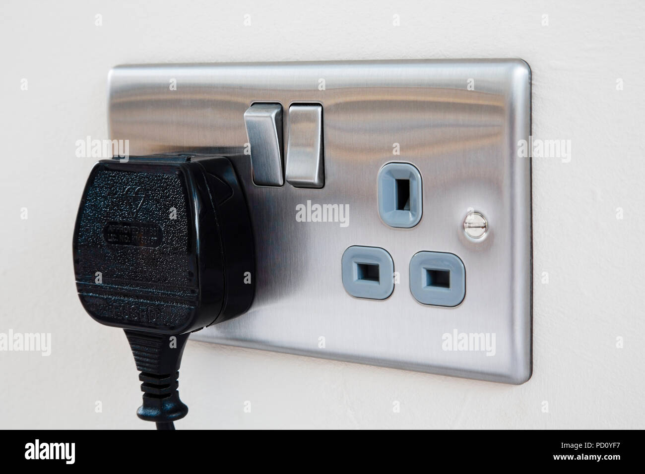 A British three pin plug plugged in to a domestic stainless steel