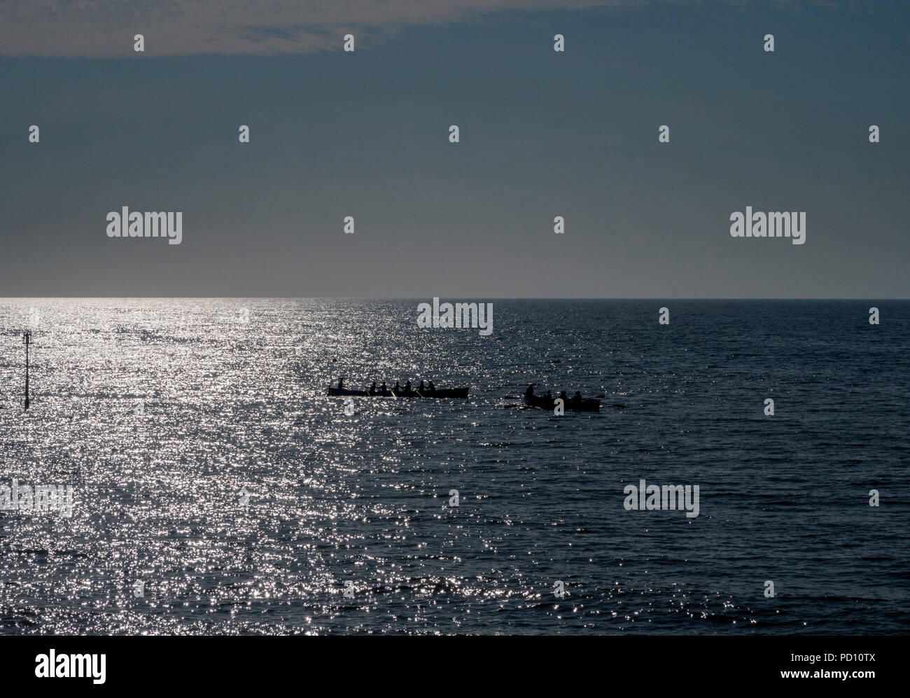 Racing gig boats set off from Sidmouth early in the morning. Stock Photo