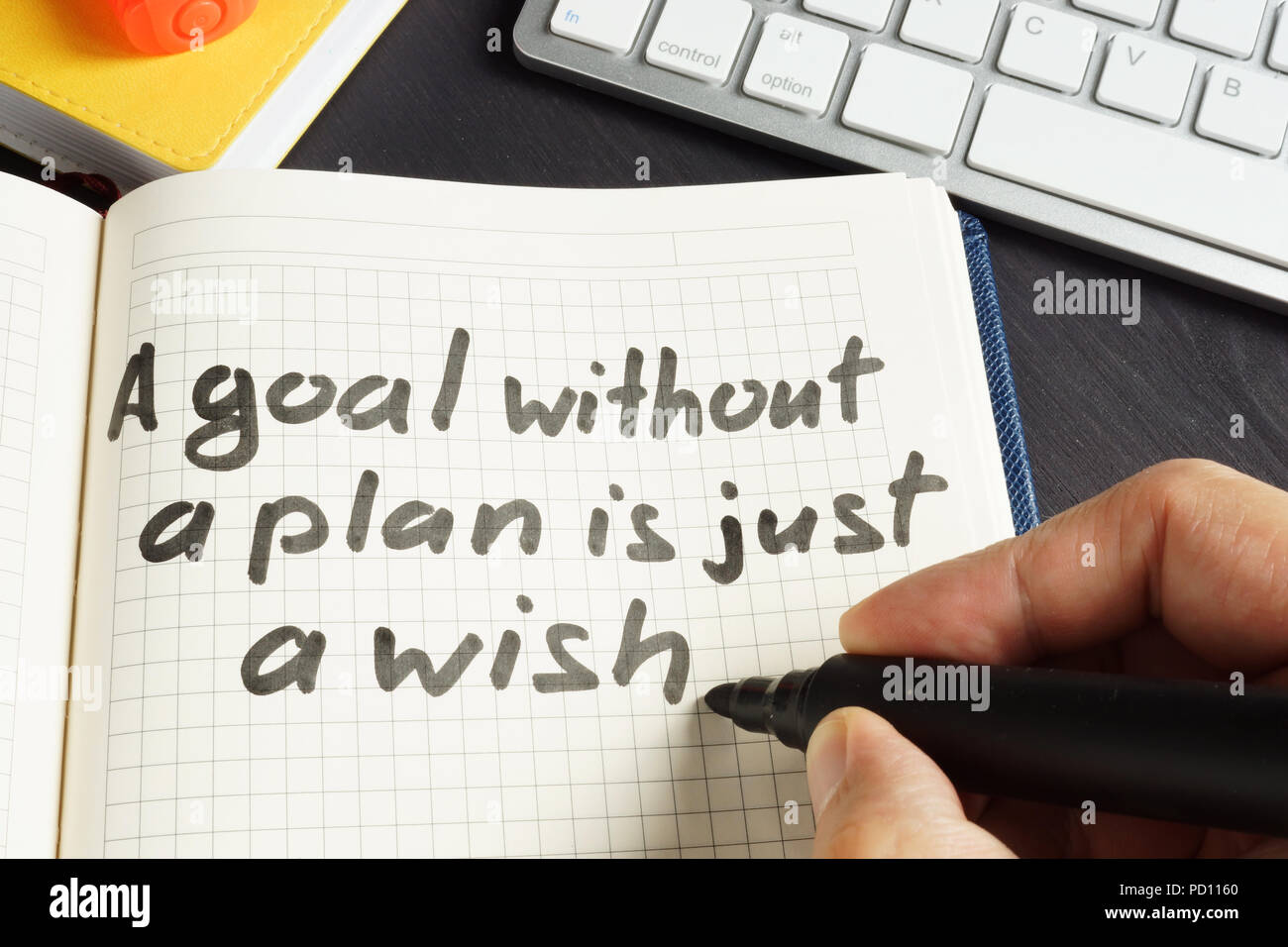 Man is writing A goal without a plan is just a wish. Stock Photo