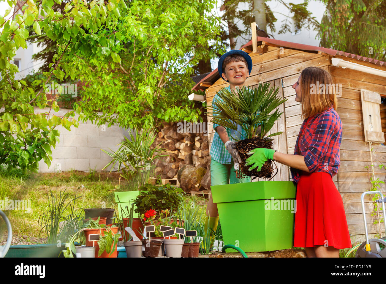 Happy boy helping his mother in the garden Stock Photo - Alamy