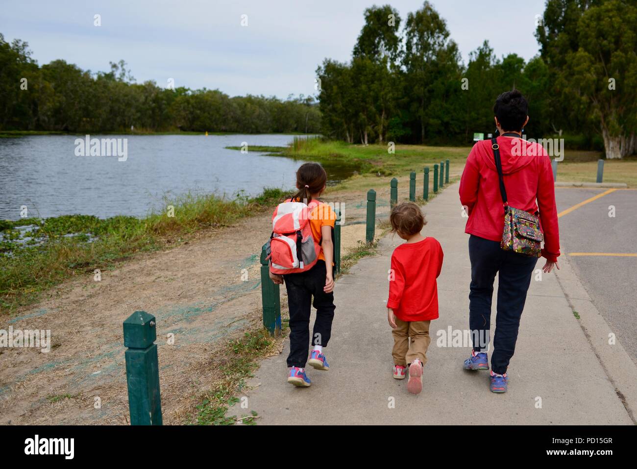 A woman and two children walk beside a river, Booroona walking trail on the Ross River, Rasmussen QLD 4815, Australia Stock Photo
