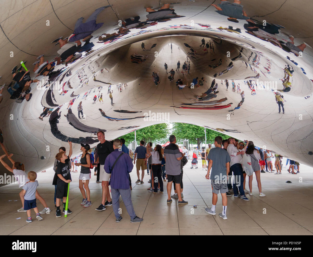 Tourists underneath the Cloud Gate sculpture in Chicago's Millennium ...