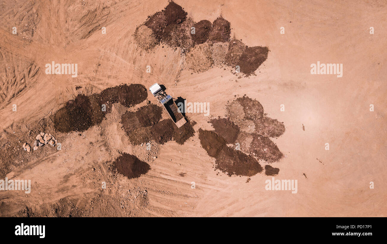 drone view of trucks unloading earth on a pile Stock Photo