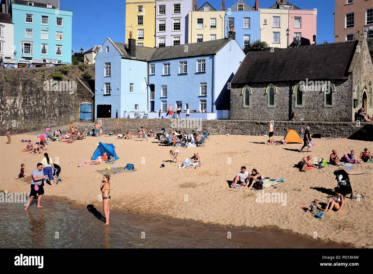 Tenby, Pembrokeshire, South Wales, UK. July 25, 2018.  Families of Holidaymakers enjoying the sands and sunshine at the Harbor beach at Tenby in South Stock Photo