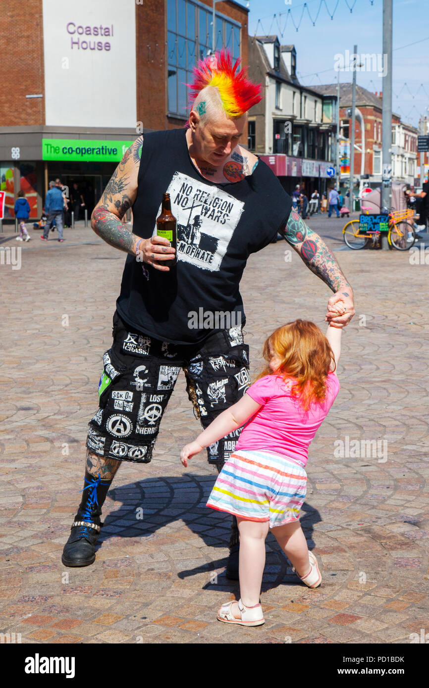 Grandad Steve 'No Religion No Wars' with grand daughter Robyn. Colourful characters at the resort Rebellion Punk Festival. Rebellion Festival, formerly Holidays in the Sun and the Wasted Festival is a British punk rock festival first held in 1996. Blackpool's annual display of coloured hair, tartan clothing and ripped leg-wear is back as every August in Blackpool, the very best in Punk gather for the social event of the year. Stock Photo