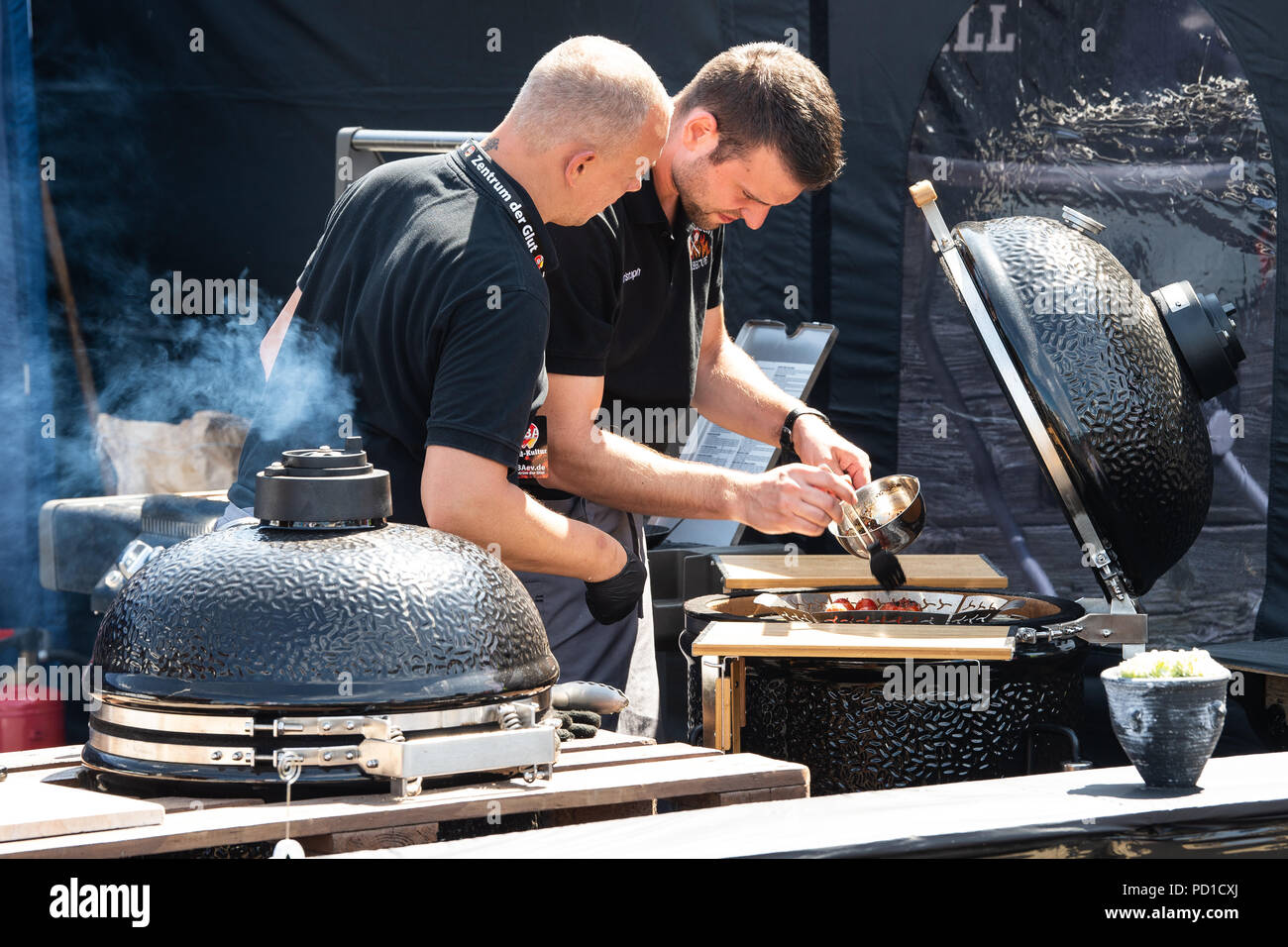 Fulda, Germany. 05th Aug, 2018. Participants stand at a kettle grill. Over  35 competition teams compete in two classes for the title of "German BBQ  King 2018". Credit: Swen Pförtner/dpa/Alamy Live News
