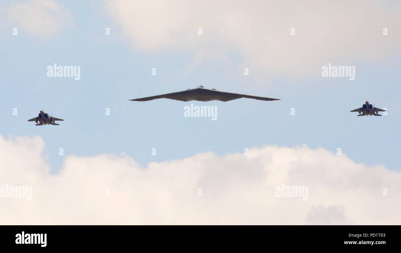 Northrop Grumman B-2 Spirit Stealth Bomber escorted by 2 McDonnell Douglas F-15 fighter jets performing a flypast at RIAT 2018 Stock Photo