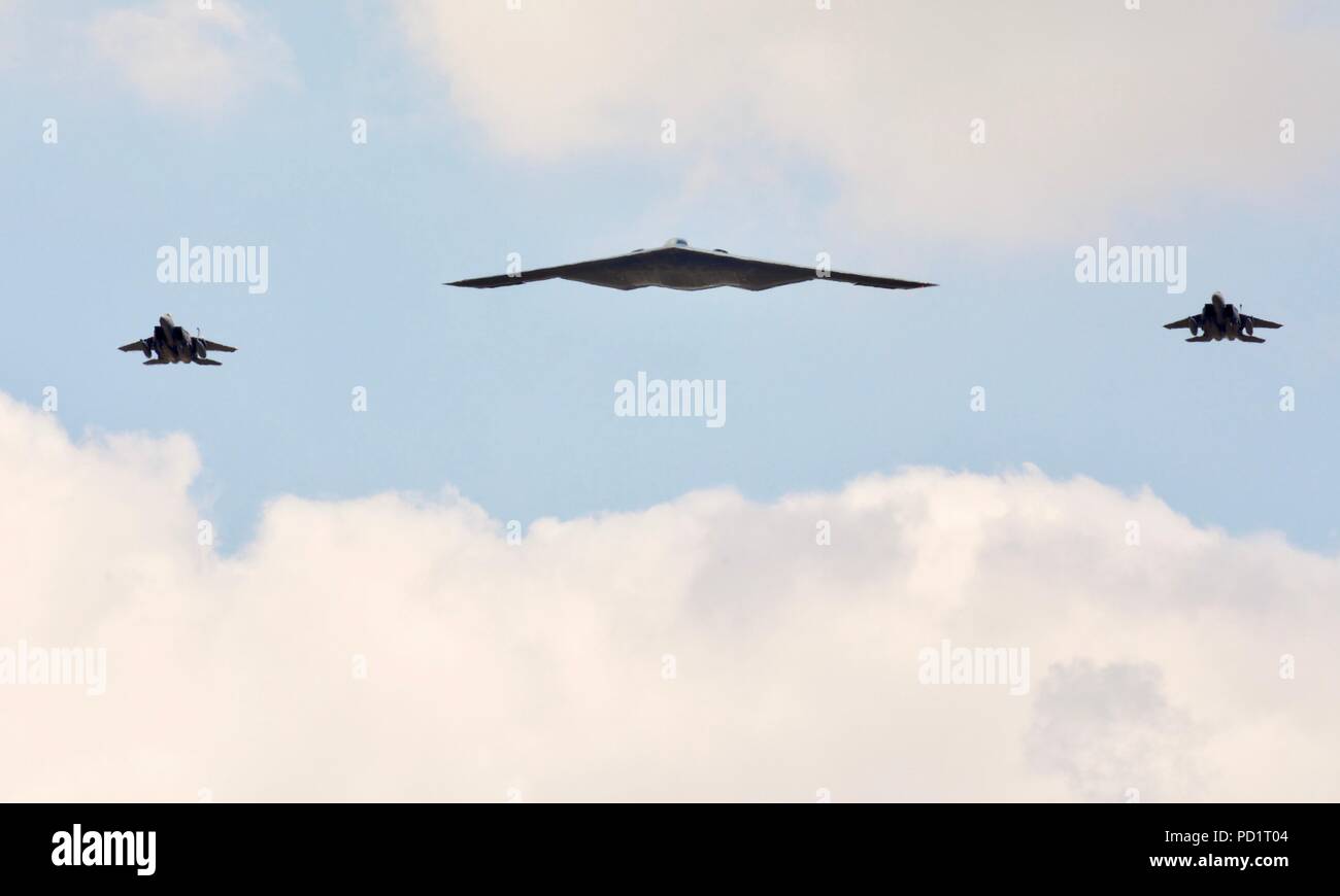 Northrop Grumman B-2 Spirit Stealth Bomber escorted by 2 McDonnell Douglas F-15 fighter jets performing a flypast at RIAT 2018 Stock Photo