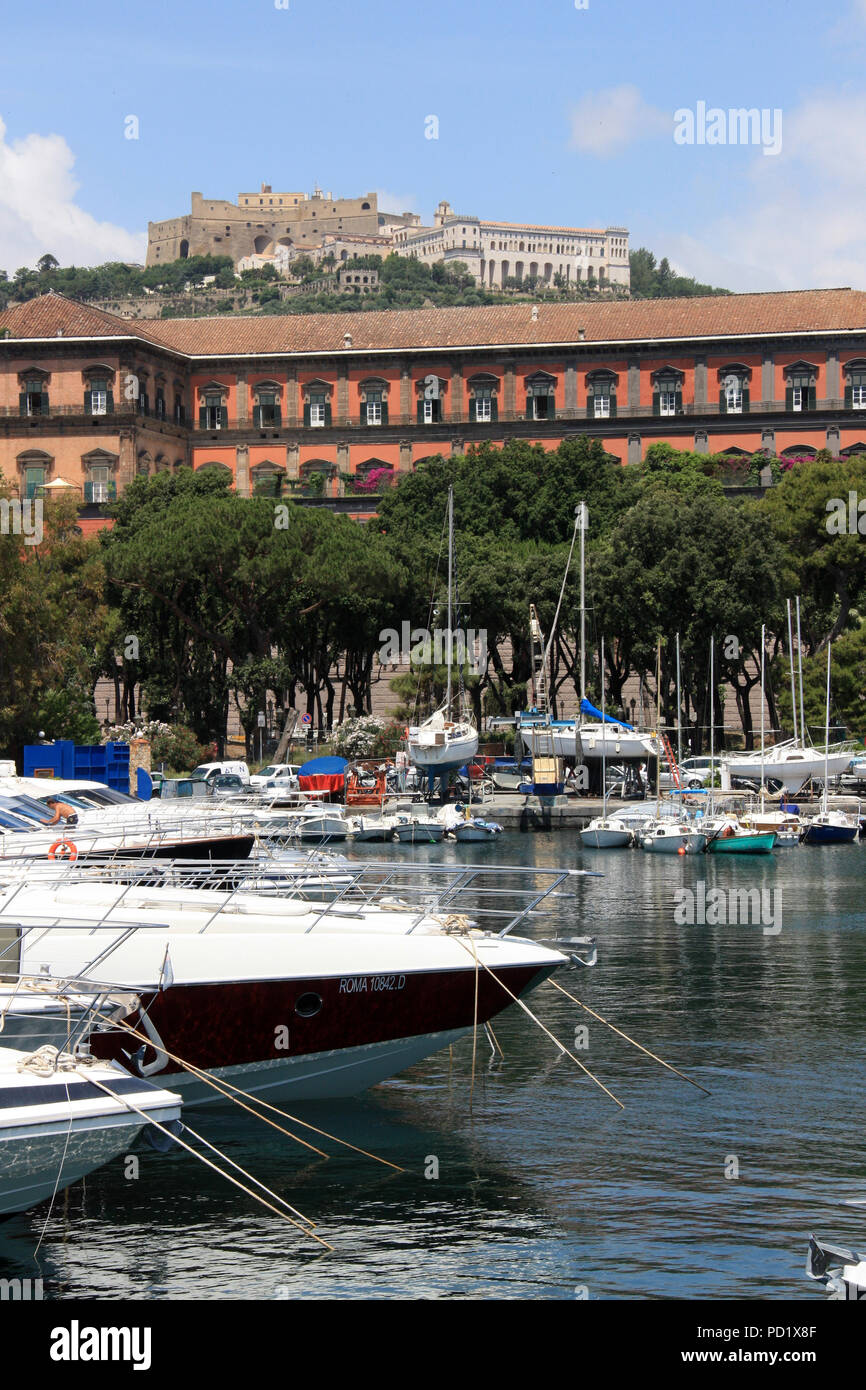 Yachts at a lovely marina with Castel Sant'Elmo, Certosa di San Martino and the Palazzo Reale di Napoli in the background - Naples, Italy Stock Photo