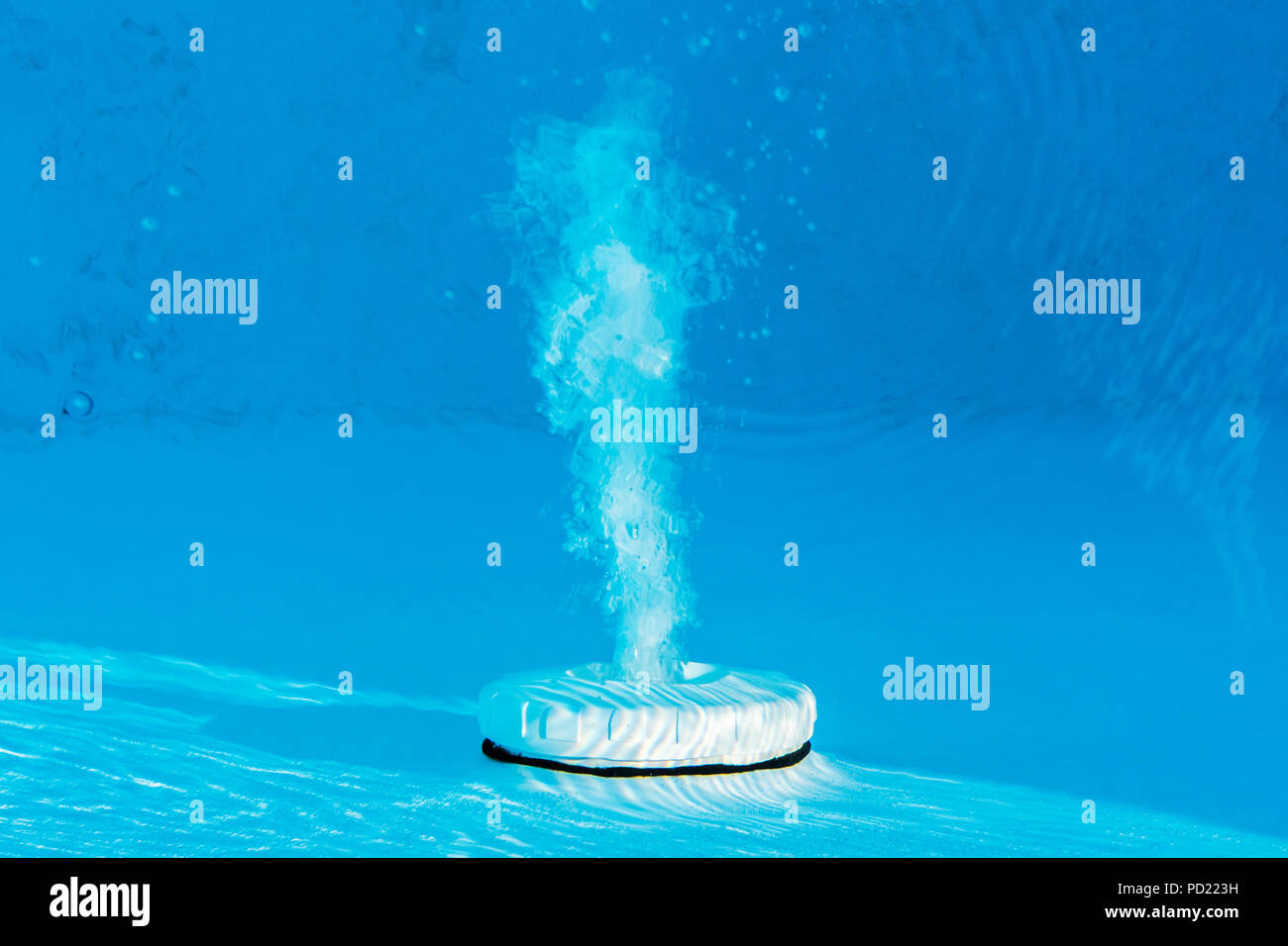 Top view of an active underwater discharge nozzle filtration system set in a blue liner swimming pool. Stock Photo