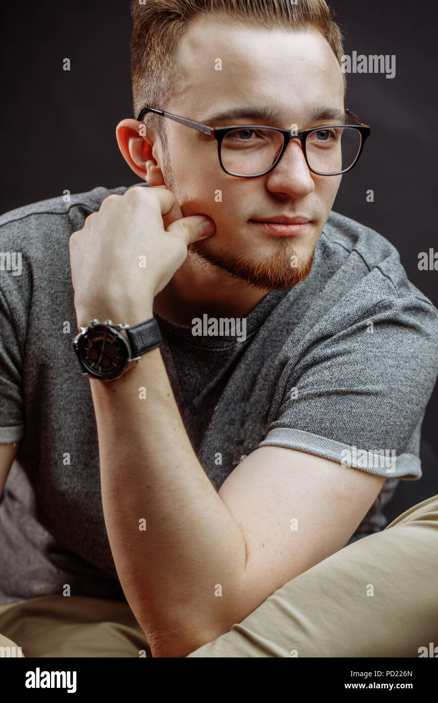 Good Looking Man With Red Hair And Beard In Glasses Sitting