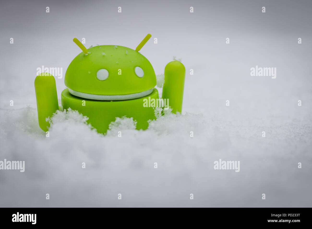 An android figure sinking in snow Stock Photo