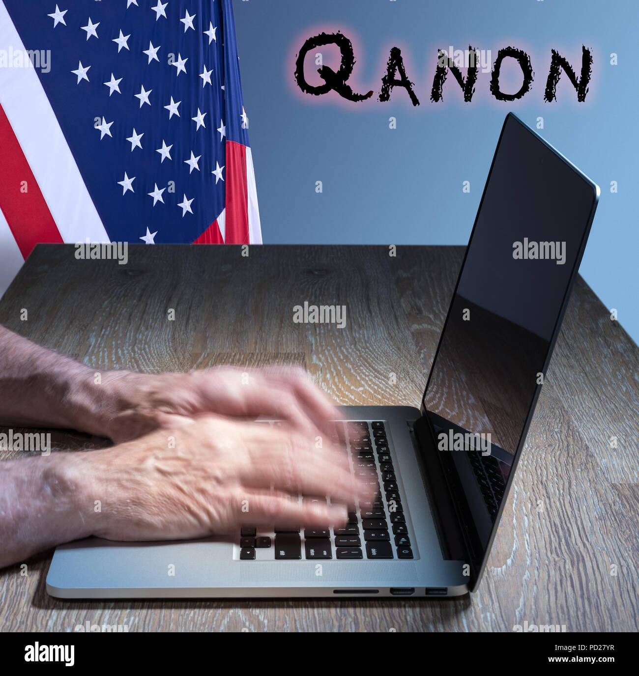 Senior caucasian man types about Q Anon deep state conspiracy Stock Photo