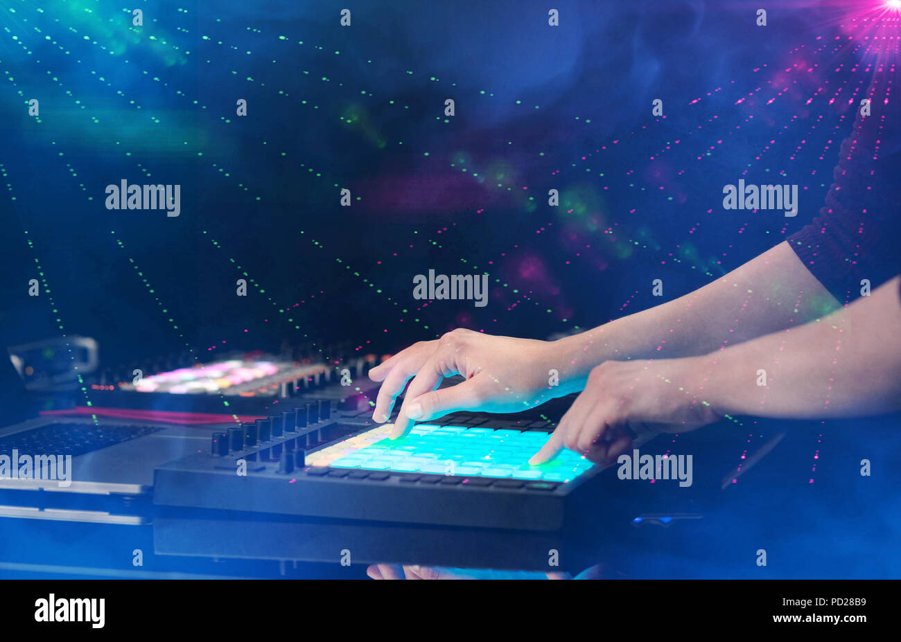 Hand mixing music on midi controller with party club colors around