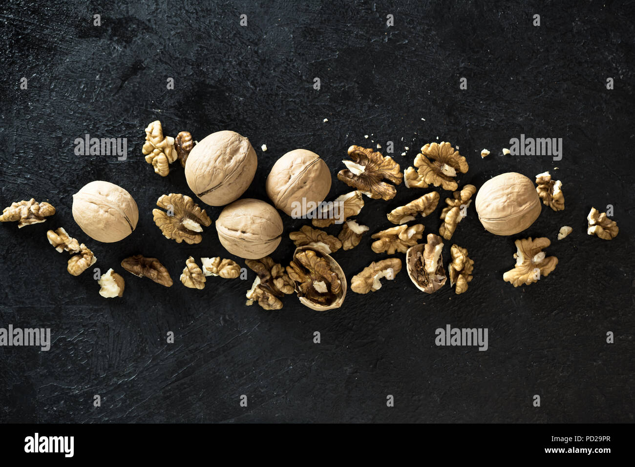Organic Walnuts. Walnuts on black stone background, top view, copy space. Stock Photo