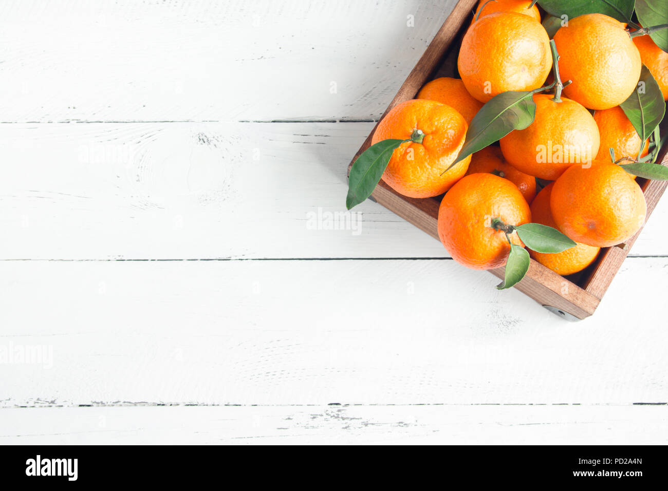 Tangerines (oranges, clementines, citrus fruits) with green leaves over